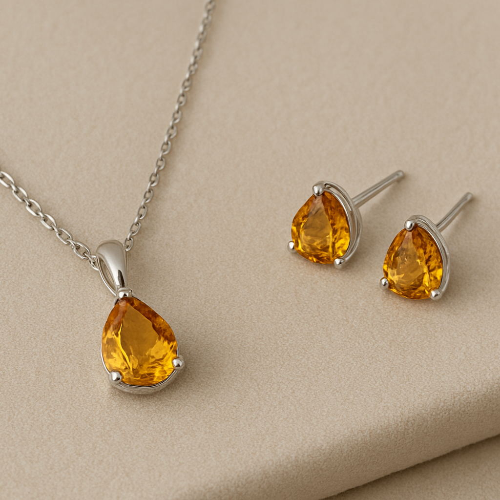 Jewelry set with teardrop-shaped amber stones on a beige background