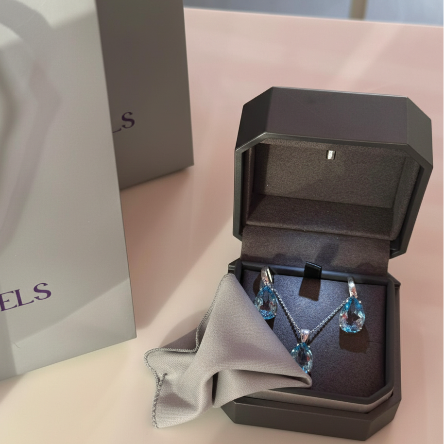 A sterling silver Sevgi Jewels ring being gently cleaned with a light gray polishing cloth, presented in a luxury silver Sevgi Jewels branded jewelry box on a clean white surface.